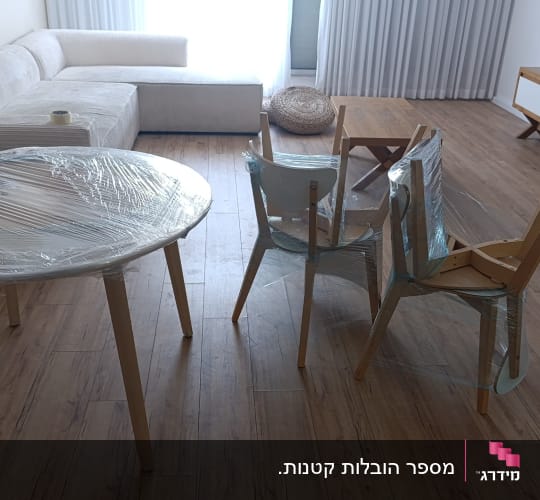 שולחן וכיסאות עטופים בניילון למעבר דירה